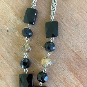 Long black gold and silver necklace with a black tassel